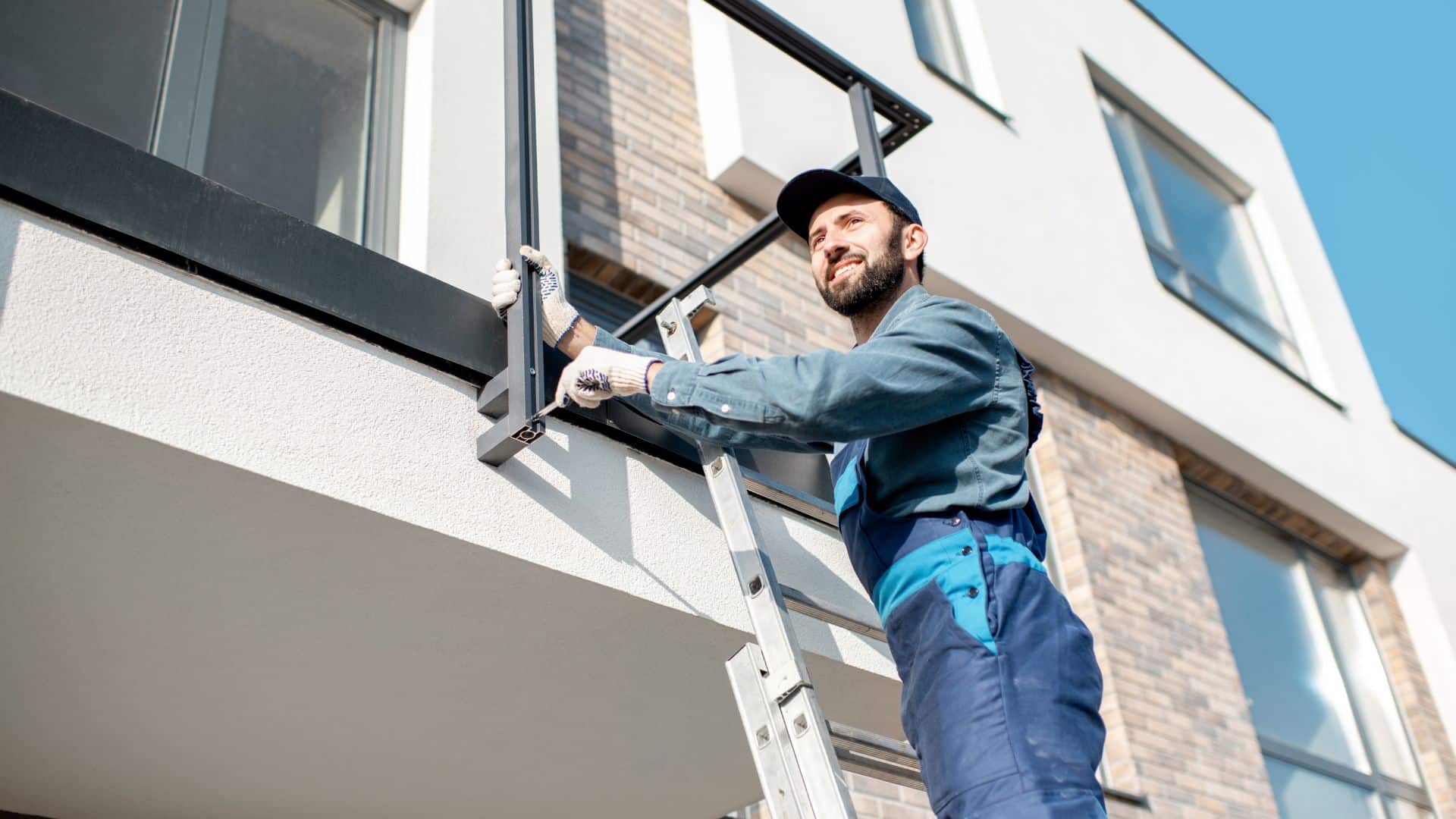 Maintenance worker repairing a balcony railing at a rental property