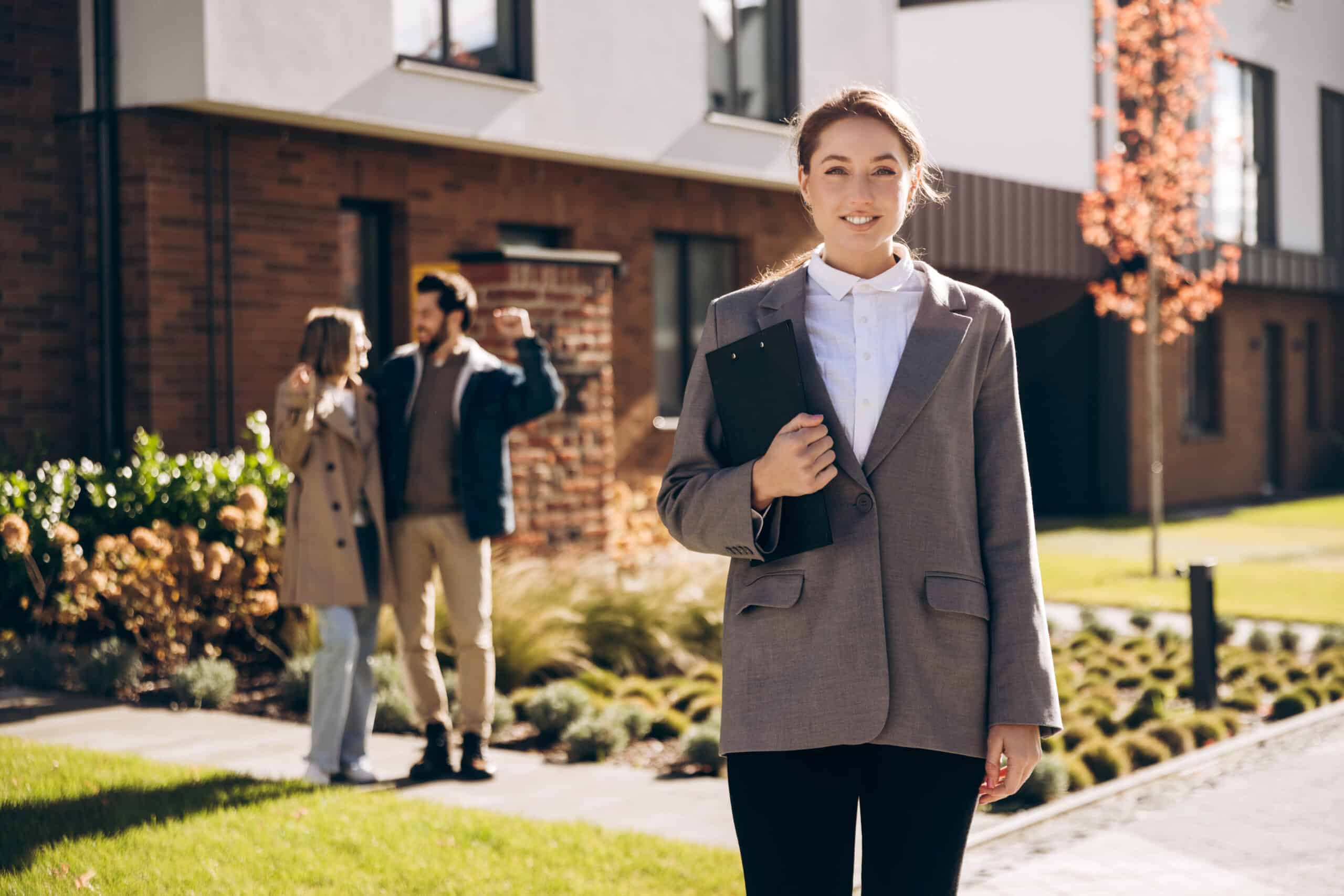 Property manager reviewing rental details with prospective tenants outdoors